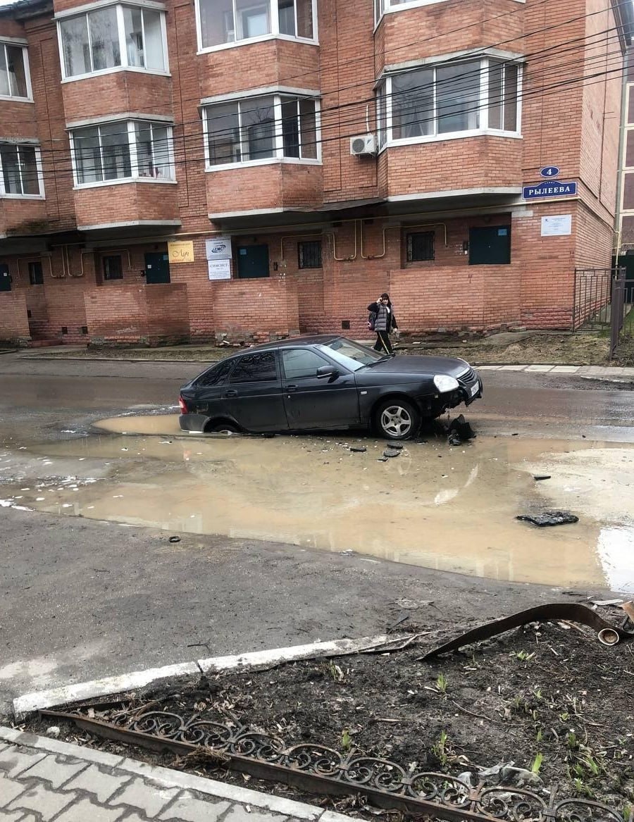«Лада Приора» провалилась в яму у дома №4 на улице Рылеева — выбоина ловко спряталась в луже